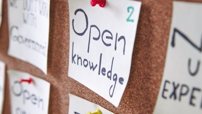 Bulletin board with pinned notes focusing on knowledge and community.